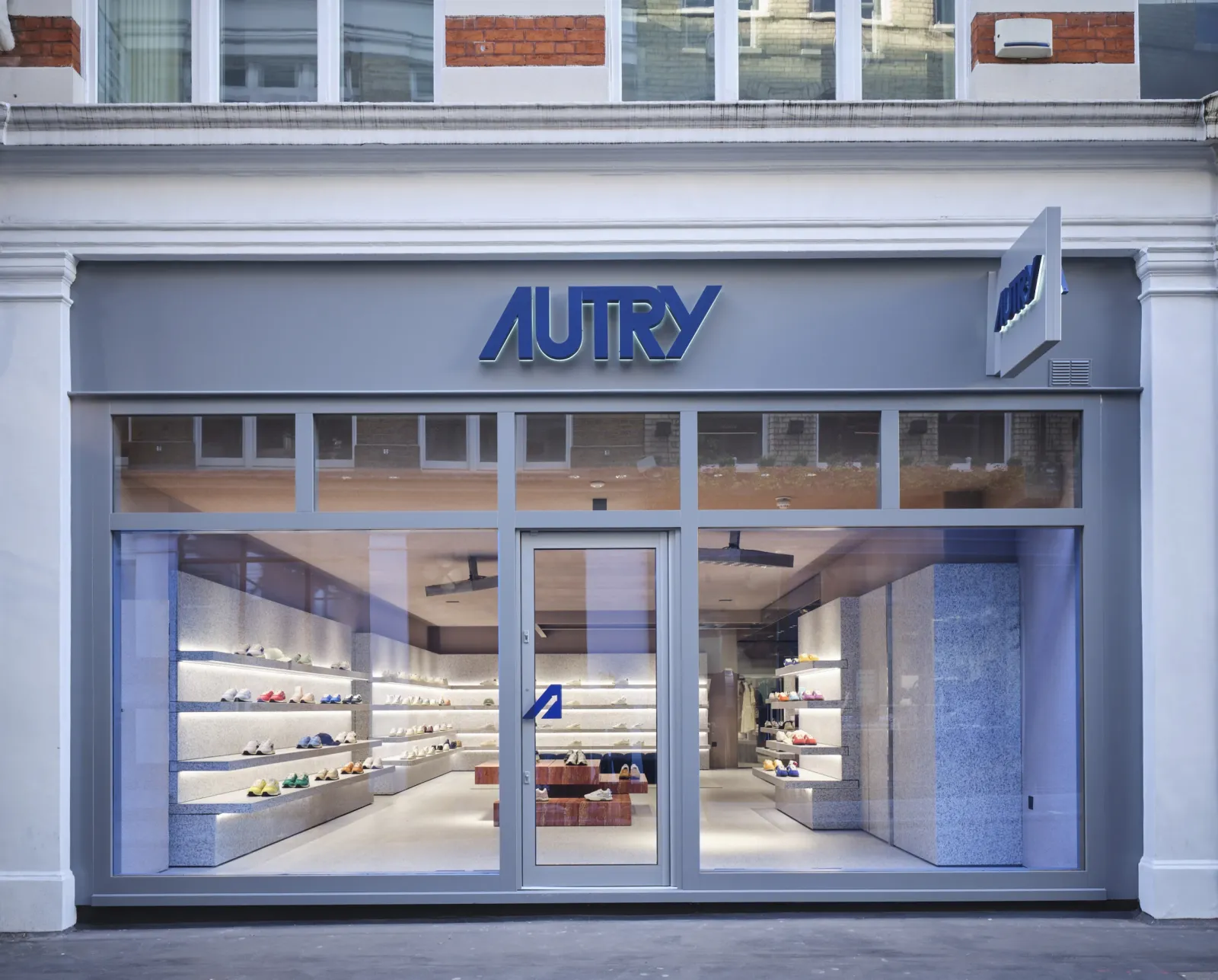 Autry sneaker store in London: minimalist grey storefront with the Autry logo and shoes on lit shelves